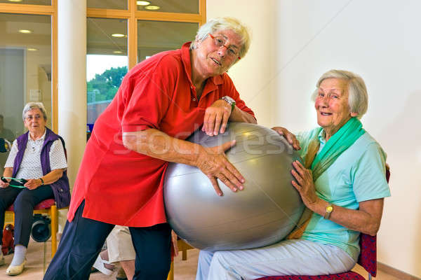 Trainer helping woman with stability ball Stock photo © belahoche