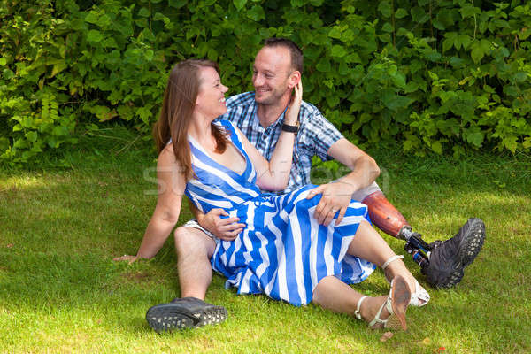 Loving couple sitting on the grass Stock photo © belahoche