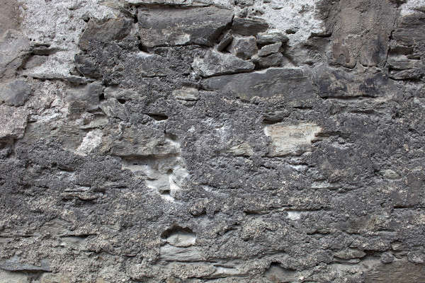 Old plastered stonewall, dark grey. Stock photo © belahoche