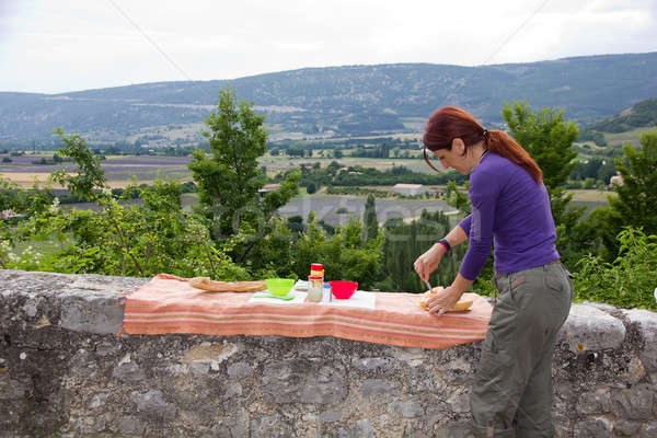 Young woman on holiday prepares dinner, France.  Stock photo © belahoche