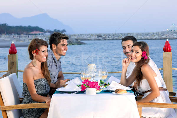 Couples celebrating at a seaside restaurant Stock photo © belahoche