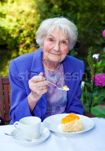 Glimlachend oude dame snacks tuin tabel Stockfoto © belahoche