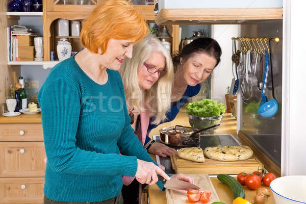 Moms Looking at their Friend Slicing Ingredients Stock photo © belahoche