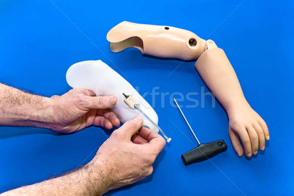 Close up on hands assembling prosthetic arm Stock photo © belahoche