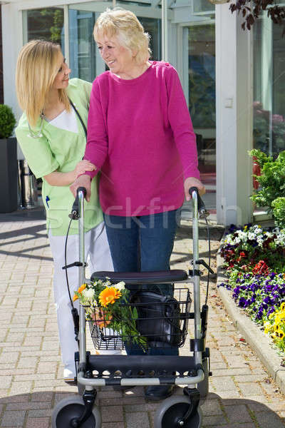 Nurse Helping Senior Woman to Walk with Walker Stock photo © belahoche
