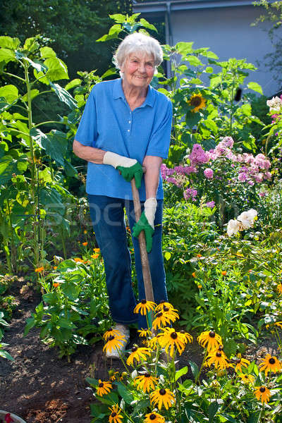 Happy Woman Planting Flowers At Her Backyard Stock Photo