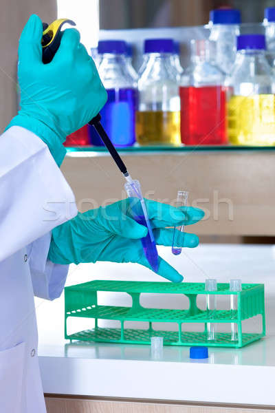Lab technician wearing gloves using a pipette.  Stock photo © belahoche