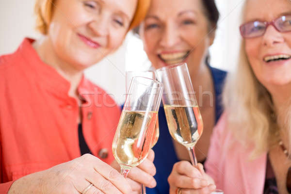 Smiling Mom Friends Tossing Glasses of Champagne Stock photo © belahoche