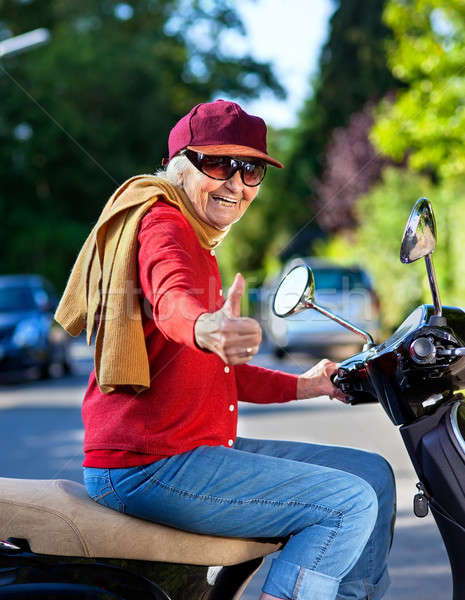 Trendy grandmother riding a scooter Stock photo © belahoche