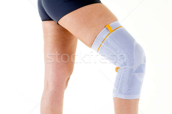Woman Wearing Flexible Knee Brace in White Studio Stock photo © belahoche