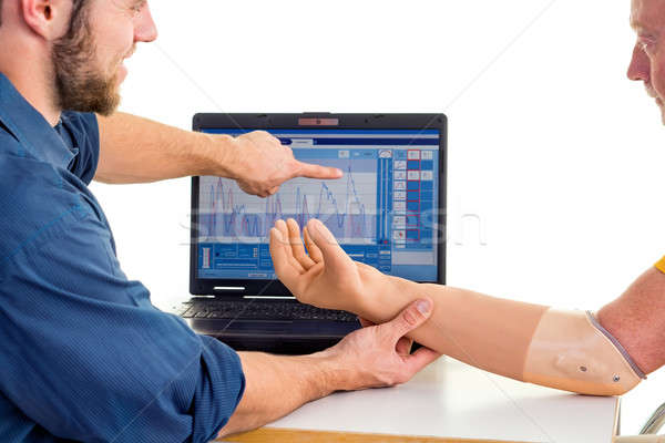 Man with prosthetic arm seeks help from technician. Computer-based adjusting. Stock photo © belahoche