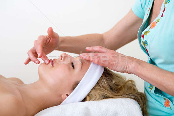 Masseuse massaging a woman lip area.  Stock photo © belahoche