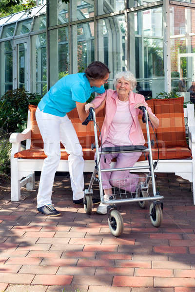 Senior woman being helped by a care assistant Stock photo © belahoche