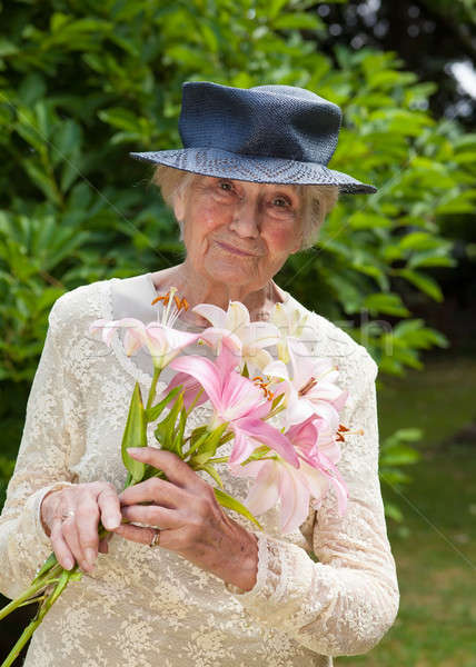Senior lady holding a bouquet of fresh lilies Stock photo © belahoche
