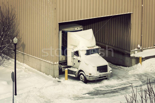 Semi truck and the warehouse seen winter time Stock photo © benkrut