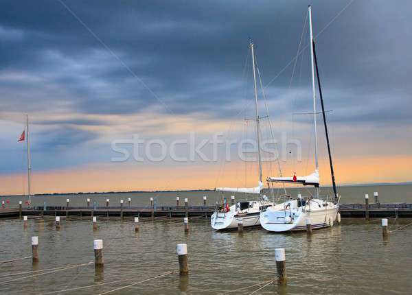 Stock photo: Stormy sunset with two yachts in marina