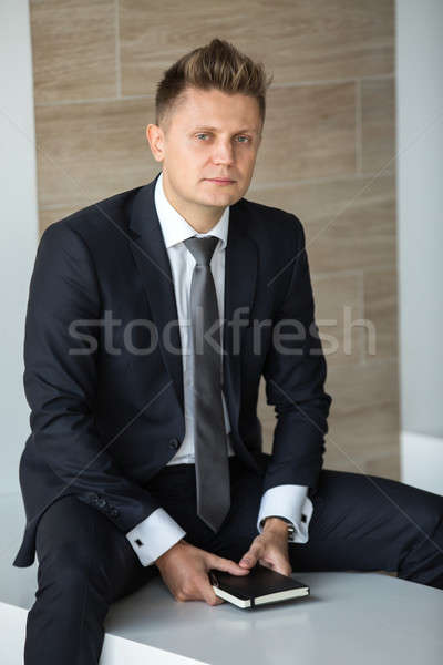 Człowiek garnitur poważny posiedzenia ławce notebooka Zdjęcia stock © bezikus
