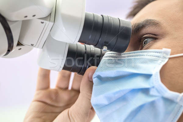 Doctor using a dental microscope Stock photo © bezikus