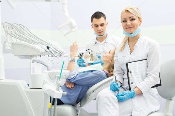 Modern dental clinic, young dentist working Stock photo © bezikus