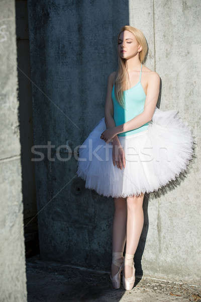 Stock photo: Graceful dancer with blond hair on the background of gray concre