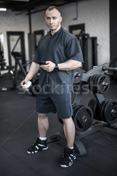 Muscular man has pause in gym Stock photo © bezikus