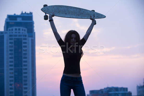 Stylish girl in jeans holding aloft longboard  Stock photo © bezikus
