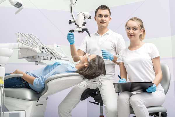 Dentist, assistant and patient in clinic Stock photo © bezikus