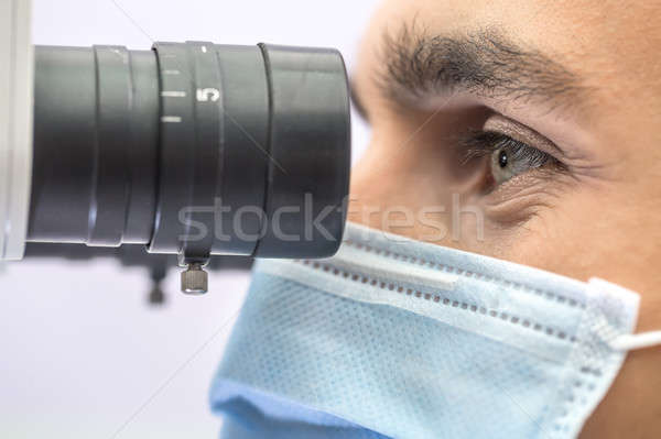 Doctor using a dental microscope Stock photo © bezikus