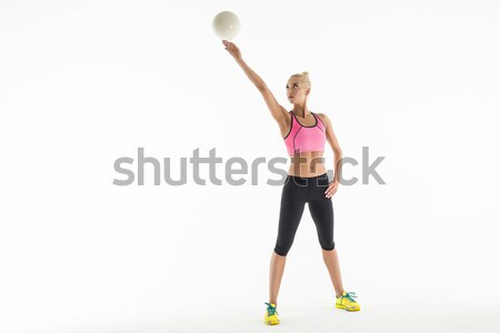 Rhythmic gymnast doing exercise with ball in studio. Stock photo © bezikus