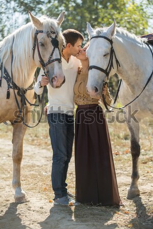 Stock photo: Young couple walking in a picturesque place with horses