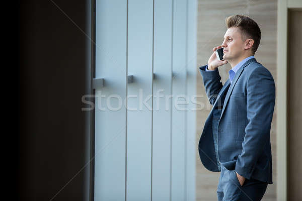 Cute człowiek biznesu czarny garnitur stałego przestronny Windows Zdjęcia stock © bezikus