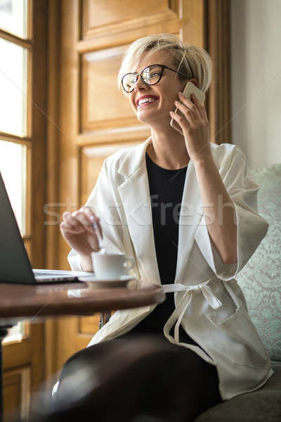 Stockfoto: Meisje · cel · cafe · blond · bril · fauteuil