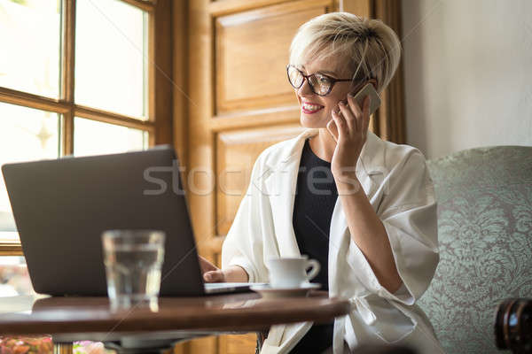 Girl talks on cell in cafe Stock photo © bezikus