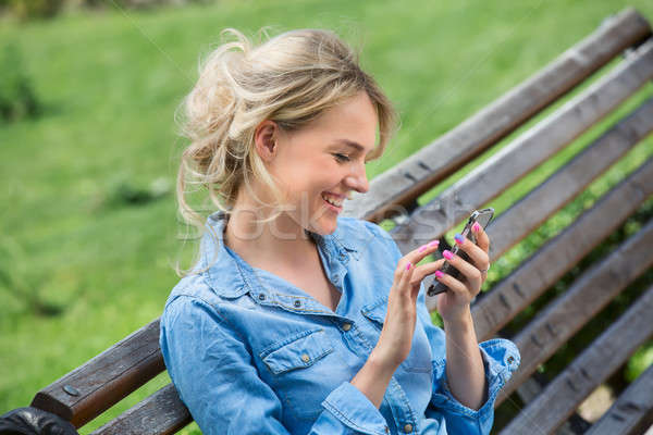 Cute blonde talking on a cell phone. Stock photo © bezikus
