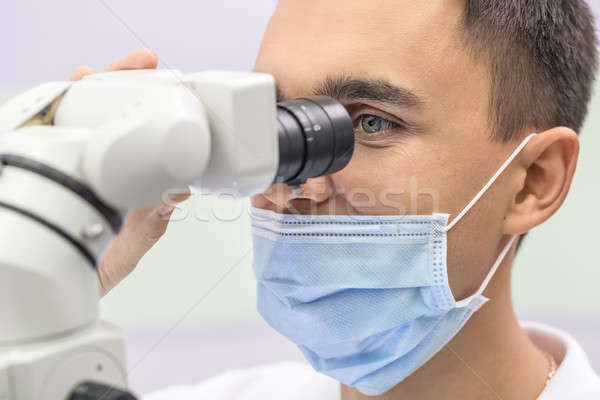 Doctor using a dental microscope Stock photo © bezikus