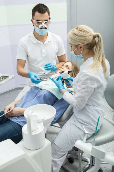 Dentist examining a patient's teeth in the dentist. Stock photo © bezikus
