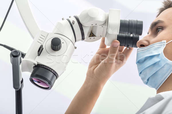 Doctor using a dental microscope Stock photo © bezikus