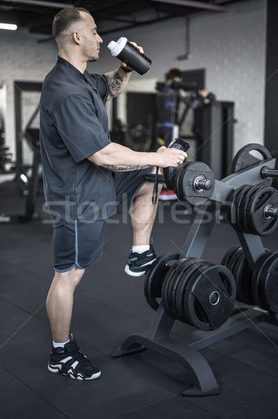 Muscular man has pause in gym Stock photo © bezikus
