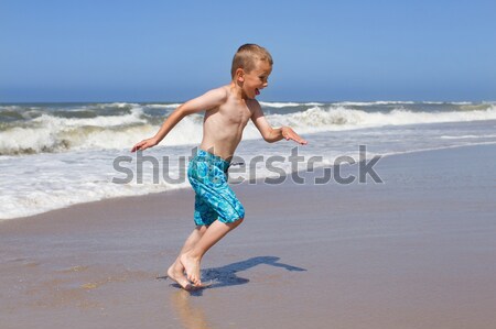 Boy running and smiling at beach Stock photo © bigandt