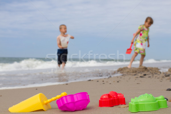 Two kids and colourful plastic toys at beach Stock photo © bigandt