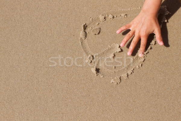 Kid hand drawing a heart in the sand Stock photo © bigandt