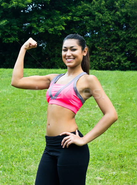Young fit woman flexes her muscles Stock photo © bigjohn36