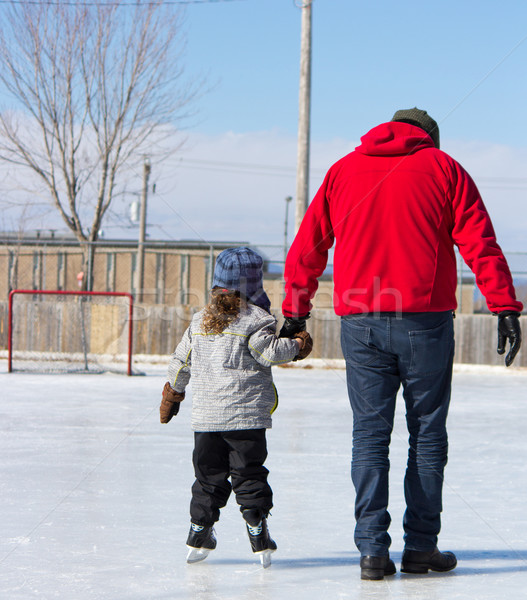 Father teaching daughter how to ice skate Stock photo © bigjohn36