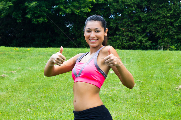 Thumbs up for a fit young woman in the park Stock photo © bigjohn36