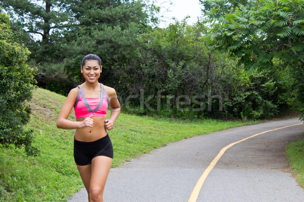 Smiling young woman running for fitness Stock photo © bigjohn36