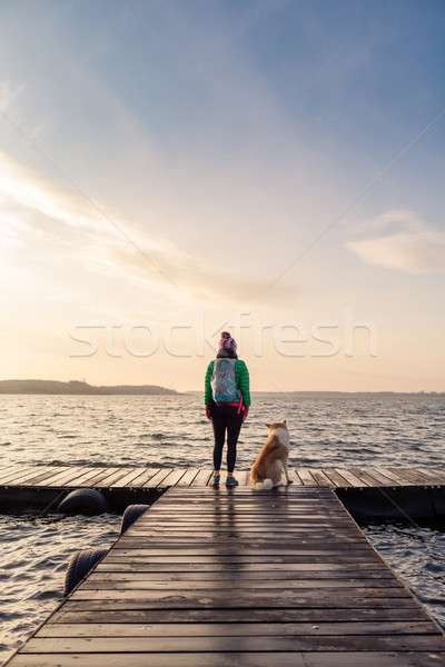 Mulher cão desfrutar nascer do sol lago backpacker Foto stock © blasbike