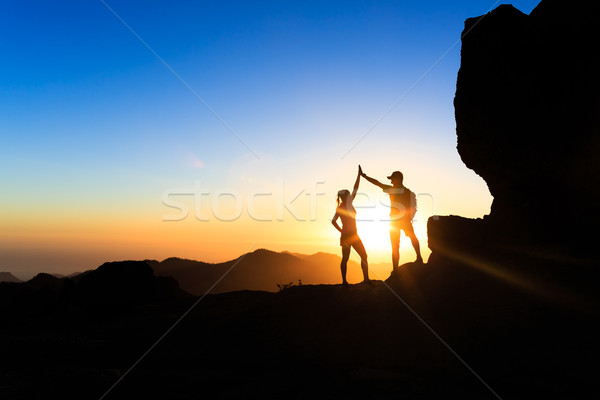Teamwork couple climbing helping hand Stock photo © blasbike