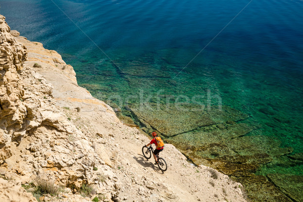 Mountain biker riding a bike on rocky trail path at sea Stock photo © blasbike