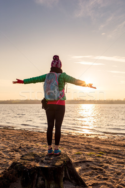 Woman hiker with arms outstretched enjoy sunrise at lake Stock photo © blasbike