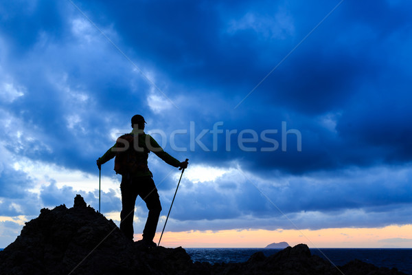 Hiking silhouette backpacker looking at sunset ocean Stock photo © blasbike